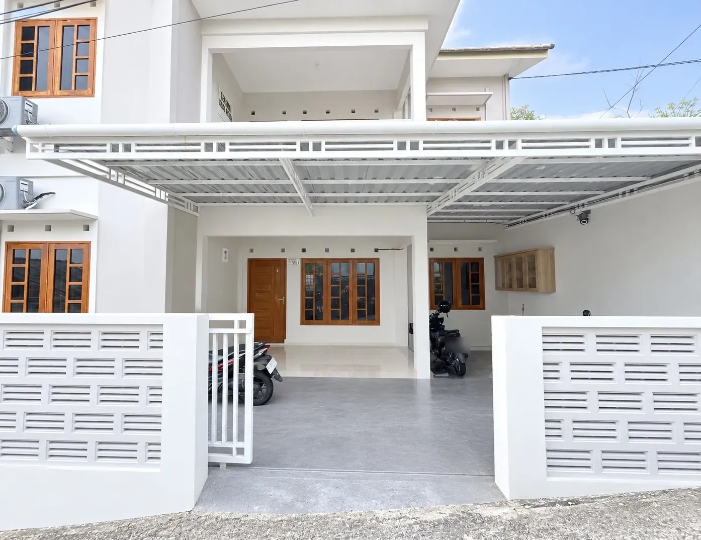 Front of the house with the covered carport and motorbike parking