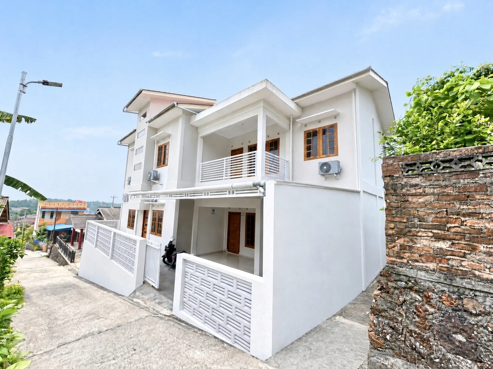 Selesa Stay, a white two-storey house with a balcony and carport on a quiet street in Tanjung Pinang